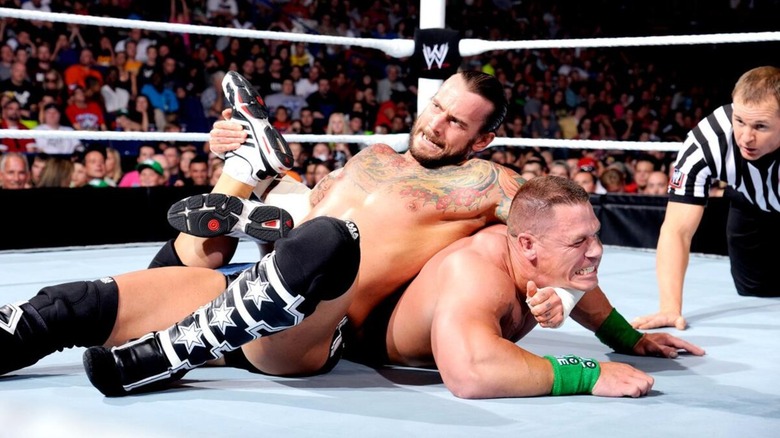 CM Punk encerrando a John Cena en un movimiento de sumisión durante un choque para el Campeonato de la WWE en 