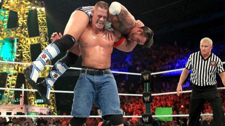 John Cena gets CM Punk up on his shoulders for an Attitude Adjustment during their 2011 Money in the Bank match for the WWE Championship.