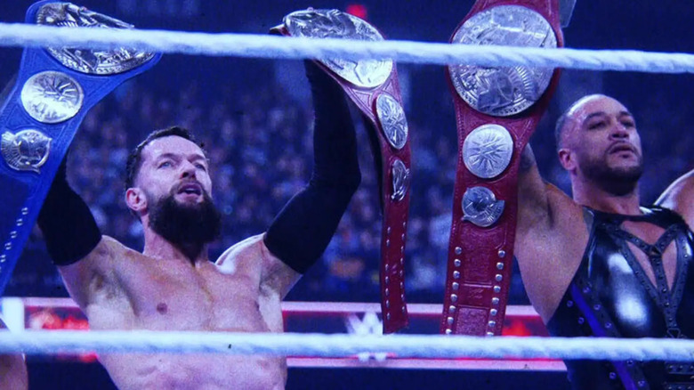 Finn Balor and Damian Priest raise their Undisputed WWE Tag Team Championships.