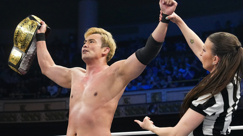 Referee Aubrey Edwards holds up the hand of AEW Continental Champion Kazuchika Okada after his victory at AEW Revolution.