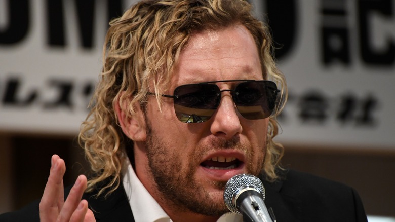Kenny Omega in sunglasses on the mic 