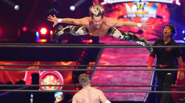 Kenny Omega dives over the top rope
