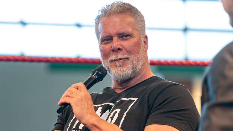Kevin Nash holding a mic and wearing an NWO shirt