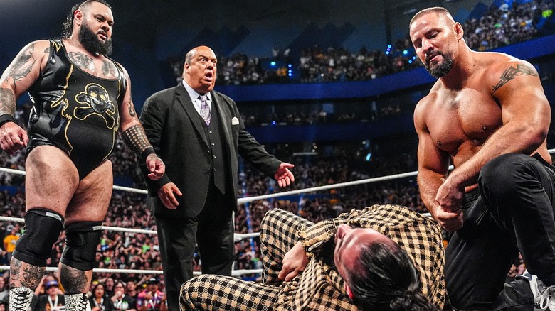 Bron Breakker and Bronson Reed standing over Seth Rollins after attacking him with Paul Heyman standing stunned between them.