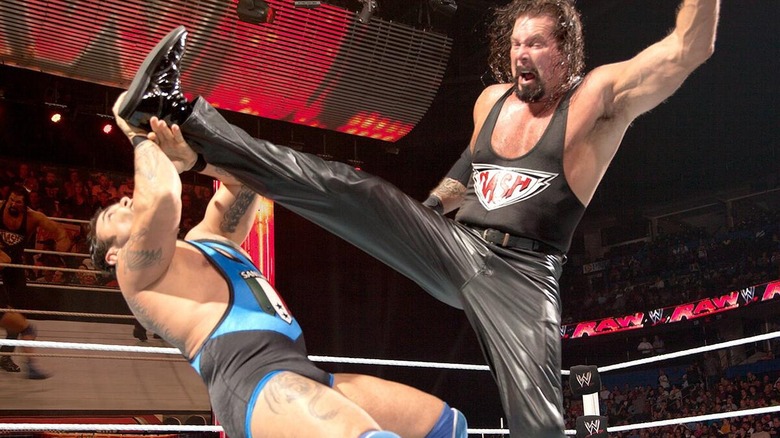 Kevin Nash hitting Santino Marella with a big boot during their clash.