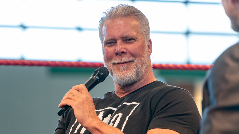 Kevin Nash smirking with a mic in hand