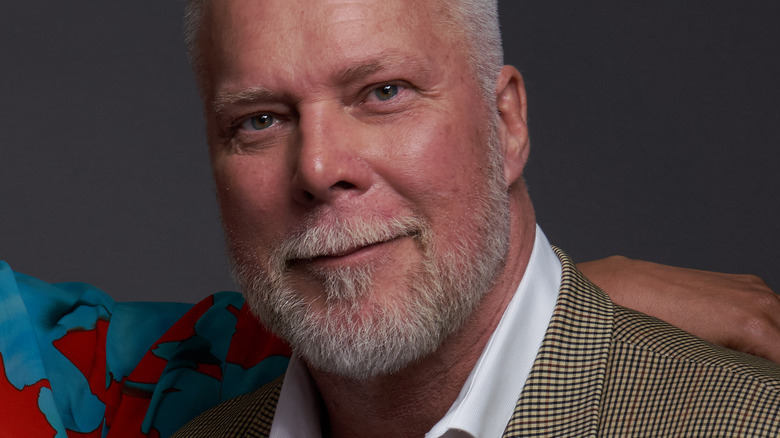 Kevin Nash smiling in a suit