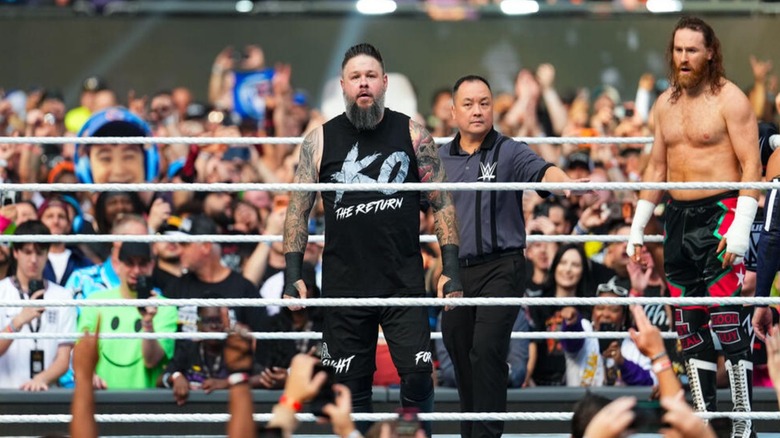 Kevin Owens stands in the ring and looks toward the crowd, as a shocked Sami Zayn looks on at his friend's return, ahead of the number one contender's four-way match at WWE SummerSlam 2026.