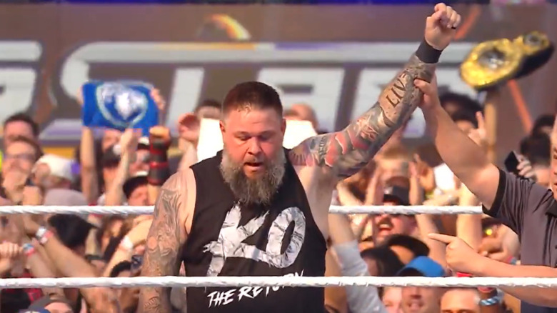 Kevin Owens with his hand raised