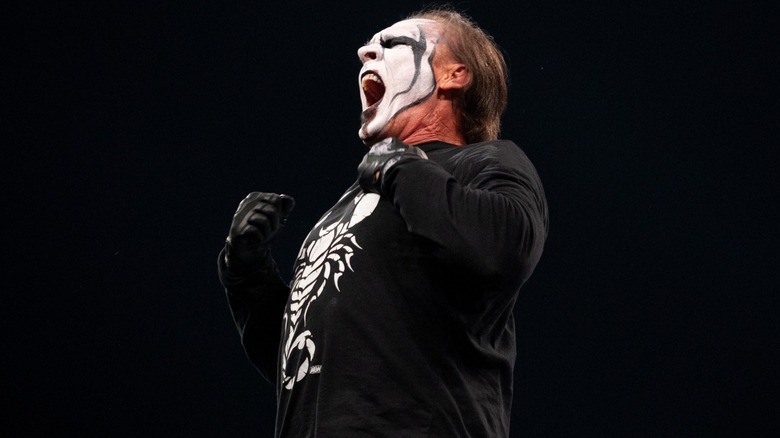 Sting pounds on his chest and lets out a yell