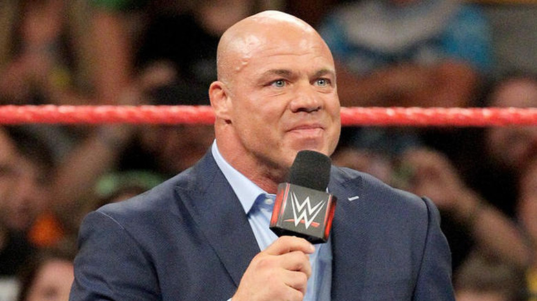 Kurt Angle smiling while holding a WWE microphone