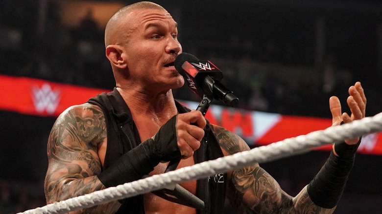 Randy Orton speaking into a microphone inside the ring
