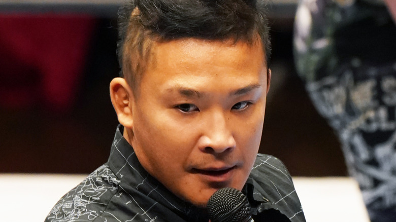 KUSHIDA holding a microphone