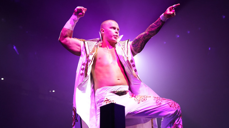 Kyle Fletcher poses on the ropes and points to the fans before a match on 