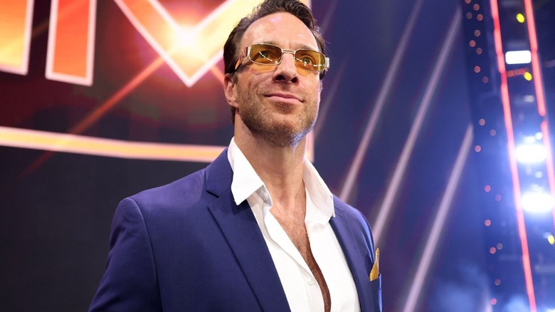 LA Knight, as his previous Max Dupri character, poses on the stage before a segment on 