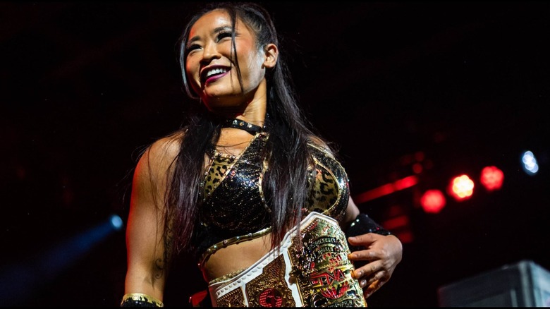 Lei Ying Lee stands on the ropes and poses with the TNA Knockouts World Championship wrapped around her waist