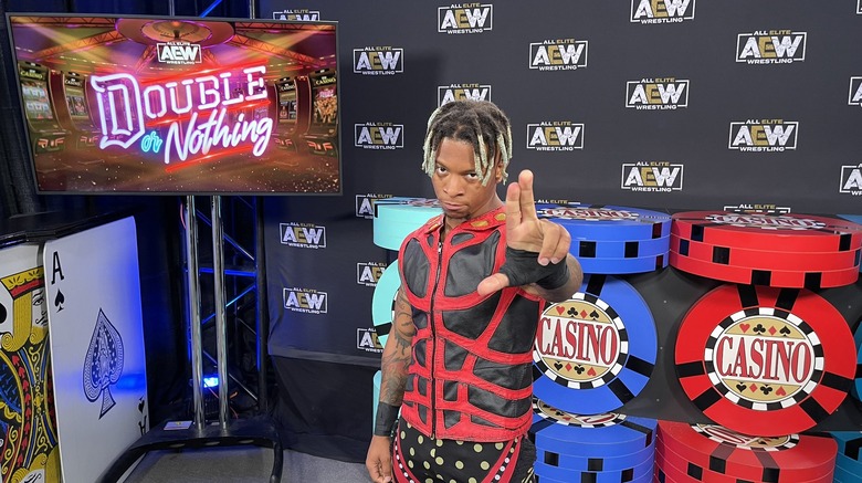 lio-rush-posing-in-front-of-AEW-sign