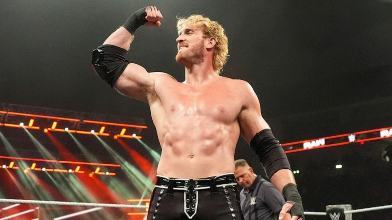 Logan Paul flexes in the middle of the ring during a match against Rey Mysterio on 