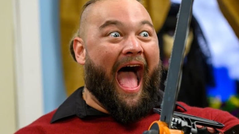 Bray Wyatt holding a chainsaw inside the firefly funhouse