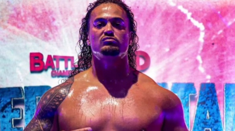 Lance Anoa'i poses with a championship belt on the stage of an event in a photo posted to his Instagram account.