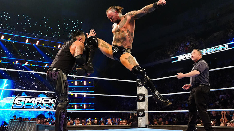 Aleister Black delivering a knee to Damian Priest