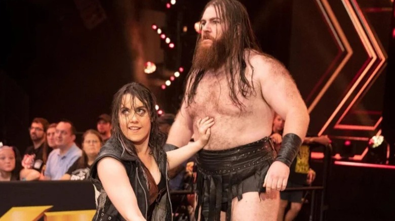 Killain Dain and Nikki Cross stand on the ramp during a match during an episode of "WWE NXT."