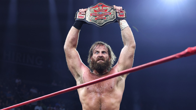 Mark Davis holds up the AEW National Championship in the ring after a victory on 
