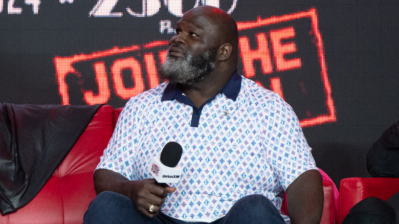 Mark Henry looks up while sitting on a couch