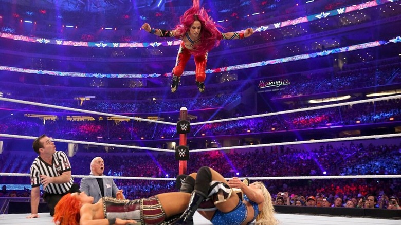 Sasha Banks flies during a frog splash attempt to Charlotte Flair, who has Becky Lynch in the figure four submission, below during their triple threat match at WrestleMania 32.