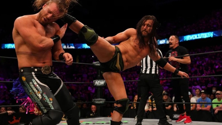 Adam Cole delivers a kick to the back of 