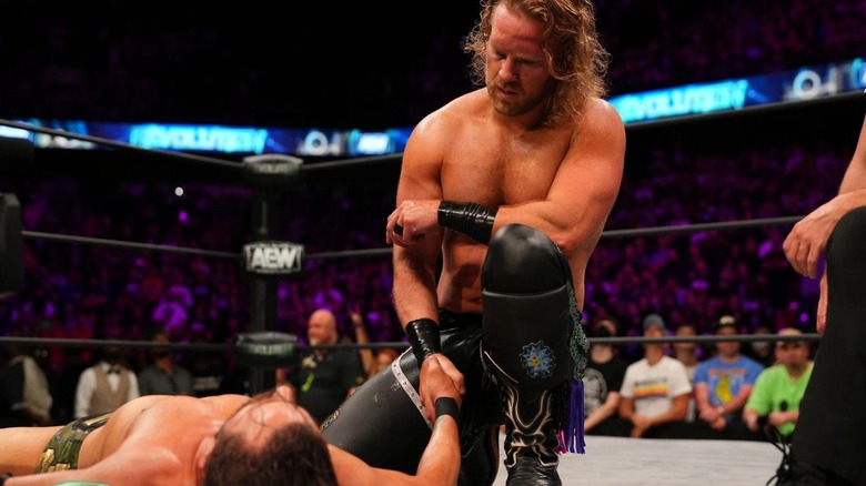 Adam Page shakes the hand of Adam Cole, who remains down on the mat, following his victory at AEW Revolution 2022.