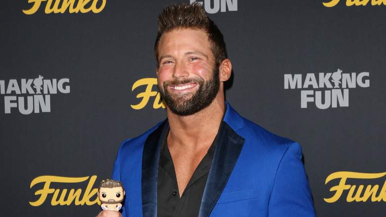 Matt Cardona posing for photo holding his Funko Pop! figure