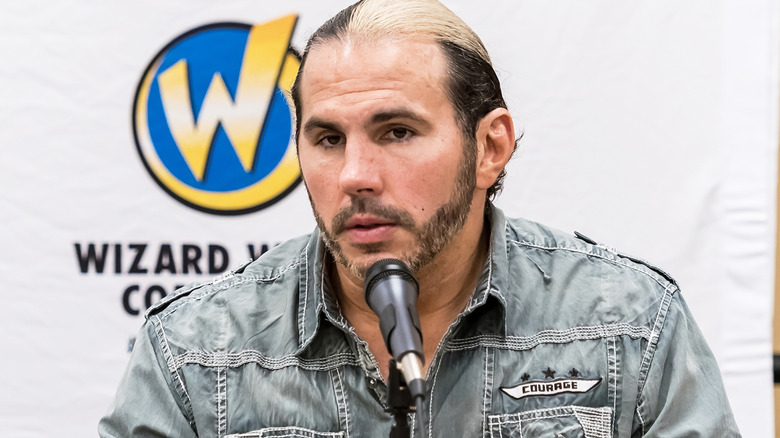 Matt Hardy is sitting in front of a microphone