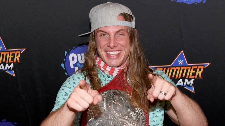 Matt Riddle wearing a WWE Tag Team Championship belt around his shoulder
