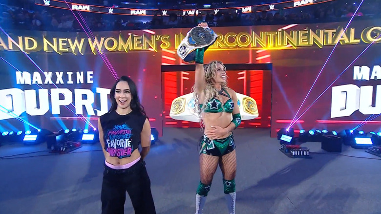 Maxxine Dupri celebrates with the Women's Intercontinental Championship alongside AJ Lee