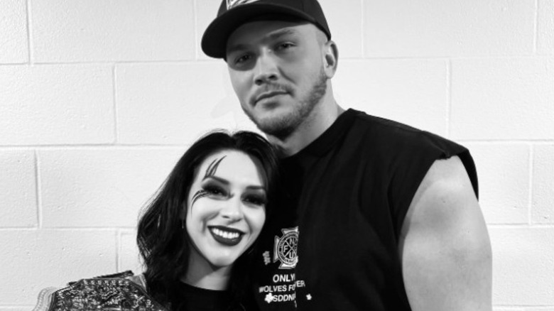 Myles Borne poses with girlfriend Stephanie Vaquer and her Women's World Championship in a black-and-white photo posted to his Instagram account.