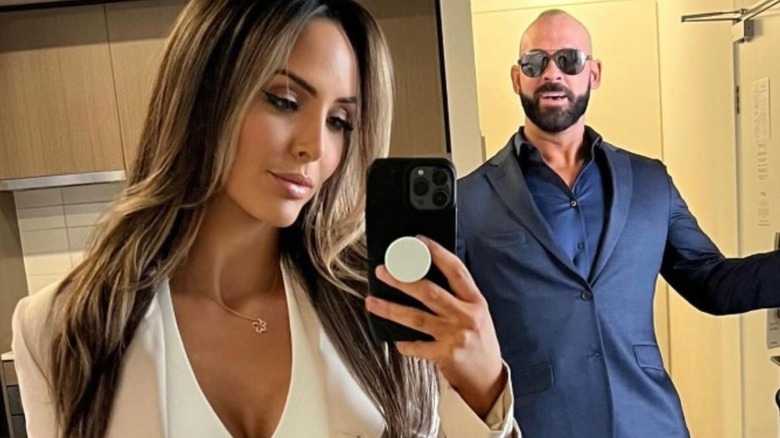 Cassie Lee takes a mirror selfie while her husband, Shawn Spears smiles from behind her in the room in a photo posted to her Instagram account.