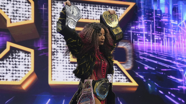 Mercedes Mone heads down to the ring with all her titles, including the TBS Championship, before a match 