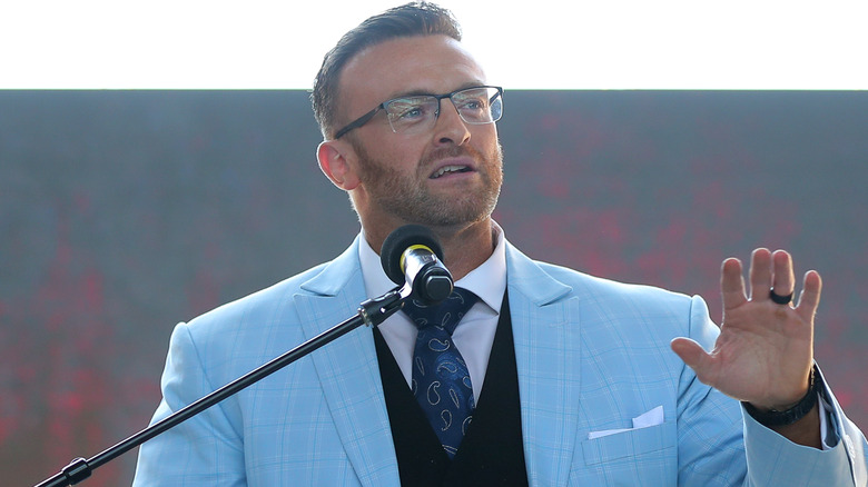 Nick Aldis wearing a blue suit