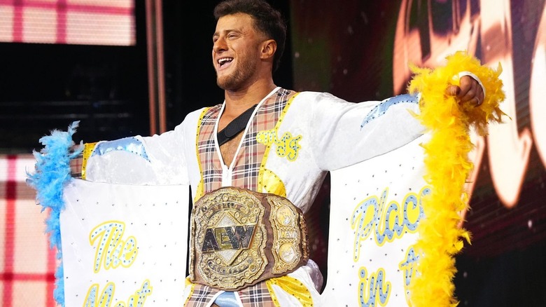 MJF with arms wide, wearing title belt