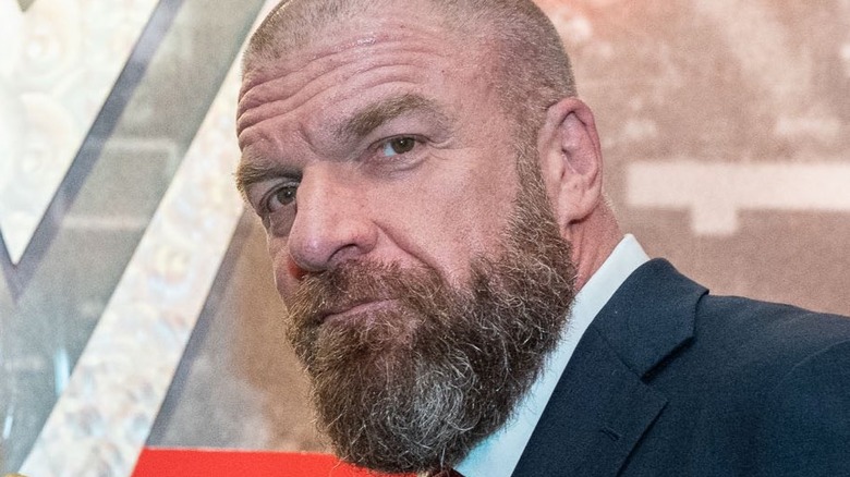 Triple H in front of WWE logo 