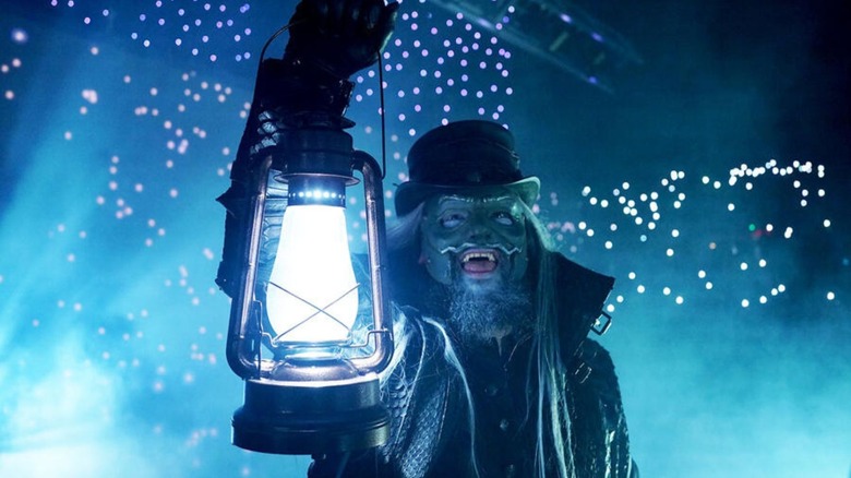 Uncle Howdy holds up the lantern during his entrance, fireflies behind him, on an episode of 