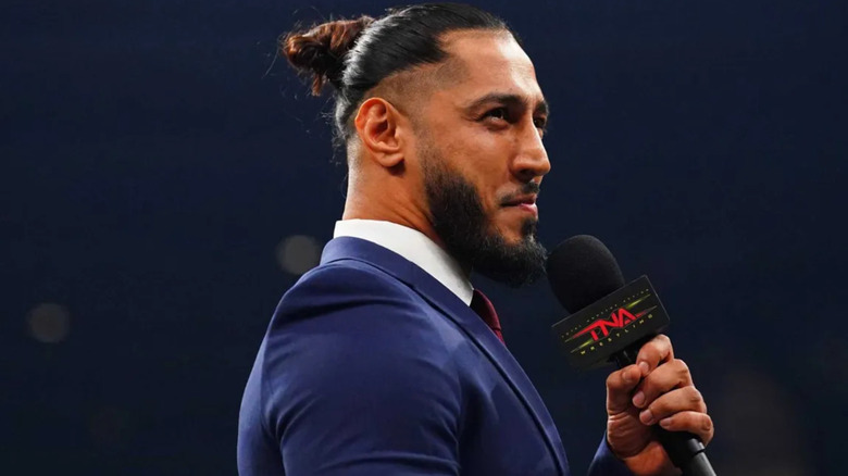 Mustafa Ali is holding a microphone