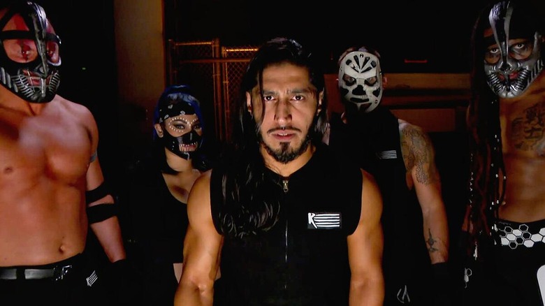 Mustafa Ali accompanied by The Retribution during a backstage promo segment.