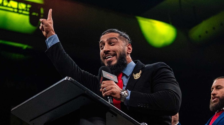 Mustafa Ali cuts a promo at the podium in the middle of the ring during an episode of 