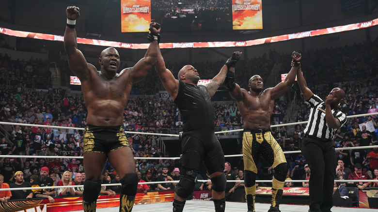 MVP and a referee hold up the arms of Shelton Benjamin and Bobby Lashley after their victory at WrestleDream.