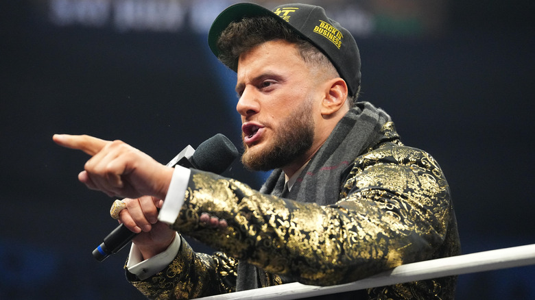 MJF wearing a baseball cap and holding an AEW mic