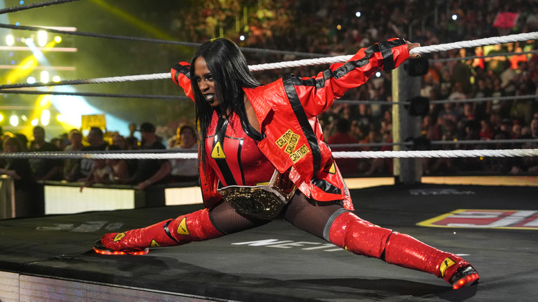 Naomi posing like a spider while making her entrance