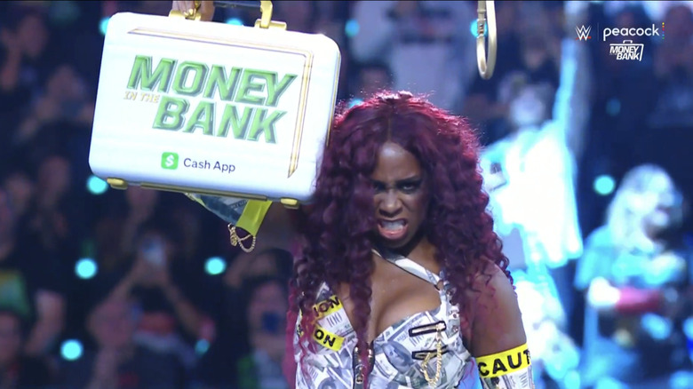 Naomi growls as she holds up the Money in the Bank briefcase
