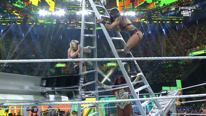 Naomi topples a ladder-bound Alexa Bliss and Rhea RIpley.